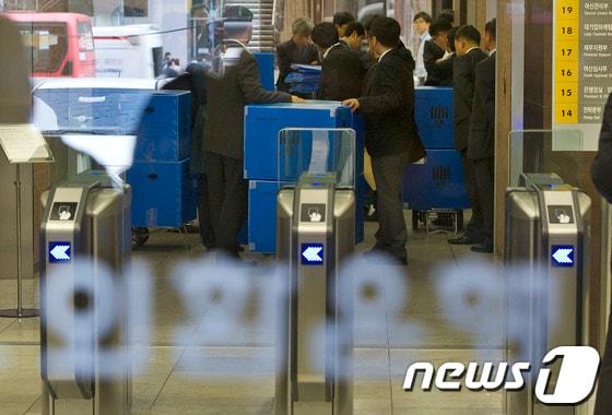 검찰 수사 관계자들이 2013년 3월 외환은행 본점에서 압수증거품을 들고 나오고 있다. 2013.3.19/뉴스1