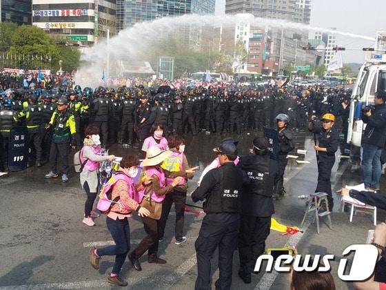 24일 민주노총 대구본부 노조원들이 새누리당 대구시당 방향으로 행진을 시도하자 경찰이 물대포를 쏘며 시위대를 해산시키고 있다. ⓒ News1 배준수 기자