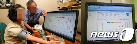 혈압을 체크하고 있는 노부부./ⓒ News1