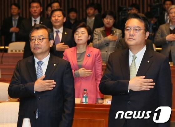 이정현 새누리당 대표와 정진석 원내대표가 1일 서울 여의도 국회에서 열린 의원총회에서 국기에 경례를 하고 있다. 2016.12.1/뉴스1 ⓒ News1 송원영 기자