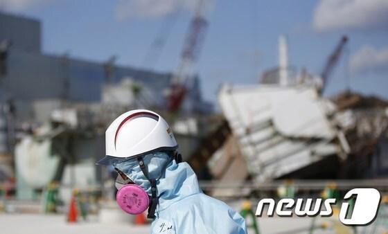 일본 후쿠시마 제1원전 앞을 지나가고 있는 원전운영사 도쿄전력의 한 직원. ⓒ AFP=뉴스1