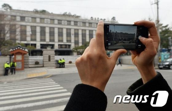 서울 종로구 재동 헌법재판소 앞에서 한 여성이 청사 전경을 휴대폰 카메라에 담고 있는 모습 ⓒ News1 오대일 기자