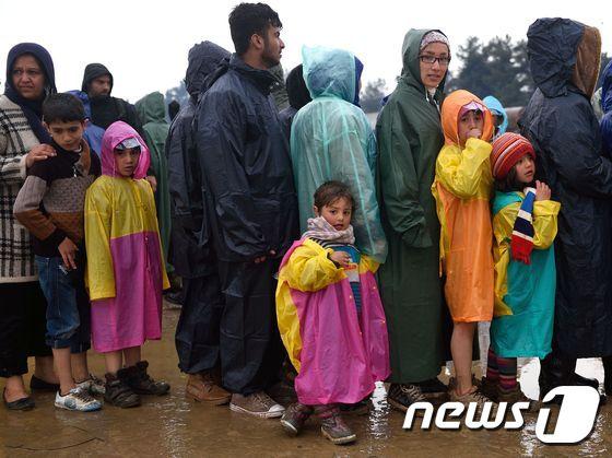 13일 &#40;현지시간&#41; 발칸 국가들의 국경 봉쇄로 발이 묶인 난민들이 그리스 이도메니의 임시보호 캠프에서 뜨거운 수프를 받기 위해 줄을 서 있다.ⓒ AFP=뉴스1 ⓒ News1 우동명 기자