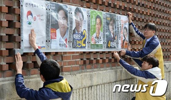 제20대 국회의원선거 선거운동개시일인 31일 오전 경기도 수원시 영덕중학교 담벽락에서 영통구선거관리위원회 직원들이 선거벽보를 붙이고 있다. 2016.3.31/뉴스1 ⓒ News1 이재명 기자