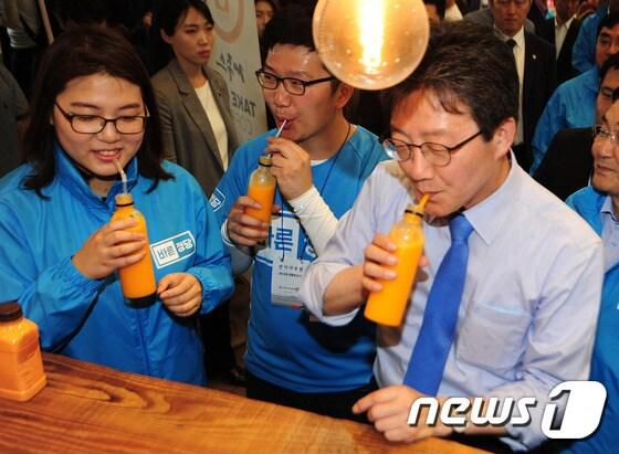 유승민 바른정당 대선후보가 아들 훈동씨 부부와 1일 제주시 동문시장을 찾아 감귤 주스를 마시고 있다.2017.5.1/뉴스1 ⓒ News1 이석형 기자