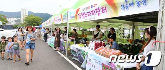 경북 김천 종합스포츠타운 일원에서 &#39;한여름 愛, 맛나자!&#39;란 주제로 열리는 제8회 김천자두·포도 축제장을 찾은 가족단위의 시민들이 행사장을 둘러보고 있다.2017.7.15/뉴스1 ⓒ News1 정우용 기자