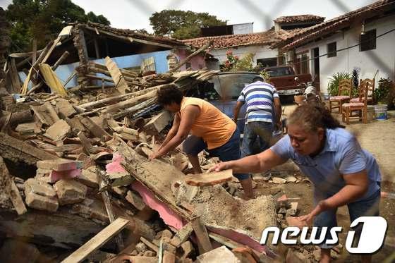 멕시코 남부 오악사카주 후치탄에서 주민들이 잔해를 걷고 있다. ⓒ AFP=뉴스1