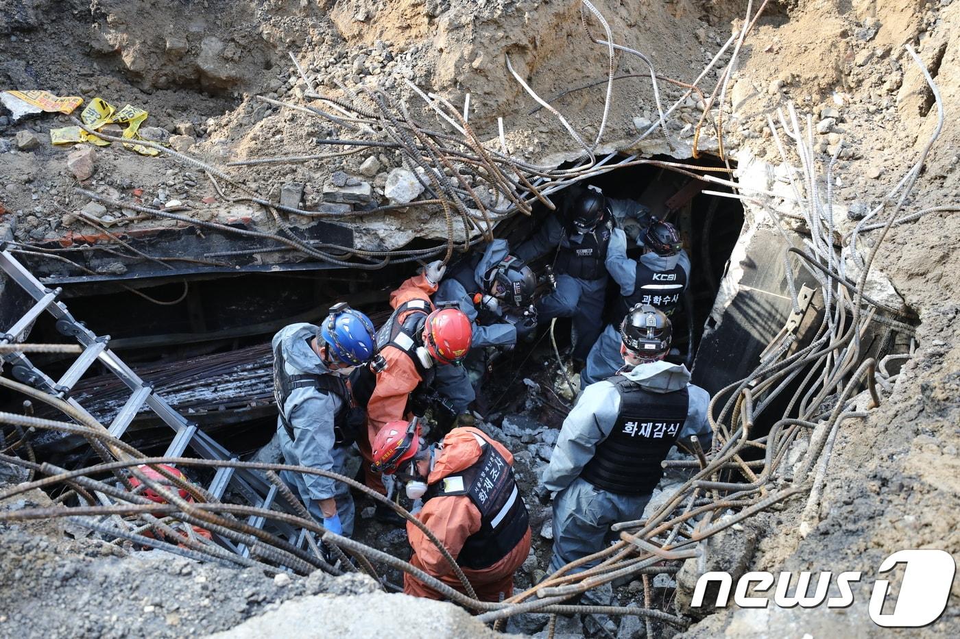 경찰과 소방대원들이 25일 오전 서울 서대문구 충정로 KT아현국사 앞 공동구 화재현장에서 전날 발생한 화재 원인을 조사하기 현장 감식을 하고 있다. 소방대원들은 전날 화재 현장 접근을 위해 공동구 화재현장에 굴착기로 땅을 파고 연기를 빼냈다.2018.11.25/뉴스1 ⓒ News1 유승관 기자