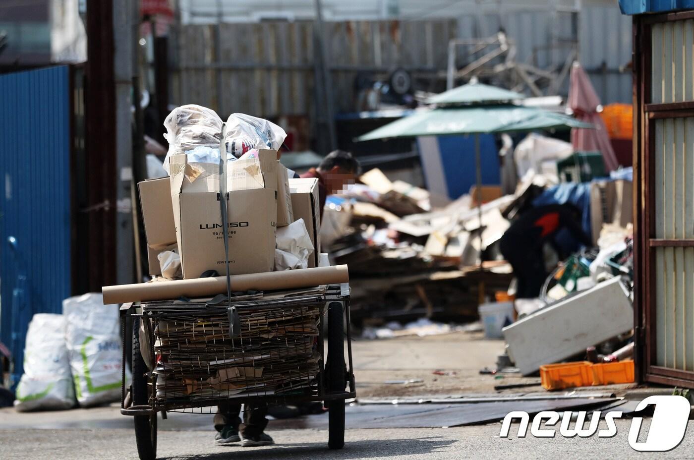 한 노인이 폐지를 손수레에 가득 싣고 재활용품 수거업체로 향하고 있다../뉴스1 ⓒ News1 