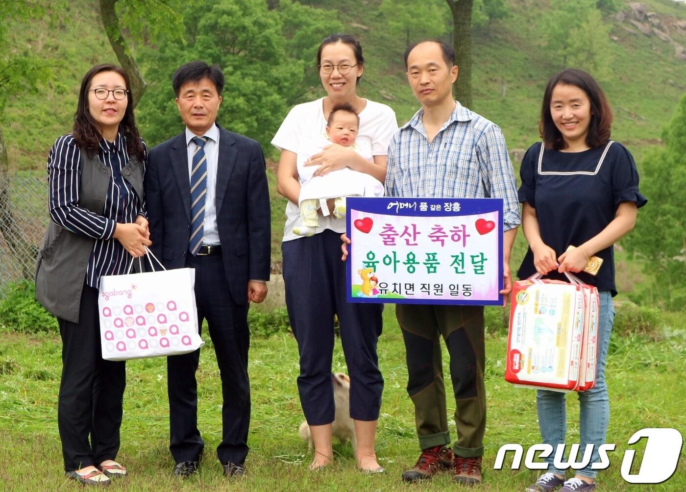 전남 장흥군 유치면사무소 관계자들이 21일 국사봉 정상 부근에서 올해 첫 아이를 출산한 장웅진·최정화씨 부부에게 출산 용품을 전달하고 기념촬영을 하고 있다.&#40;장흥군 제공&#41;2018.5.21/뉴스1 ⓒ News1