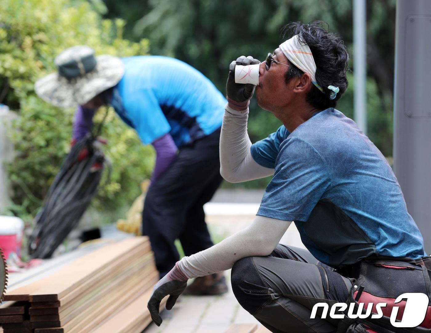 폭염이 이어지고 있는 25일 오후 서울의 한 거리에서 작업중인 노동자가 물을 마시며 더위를 식히고 있다. 2018.7.25/뉴스1 ⓒ News1 이재명 기자