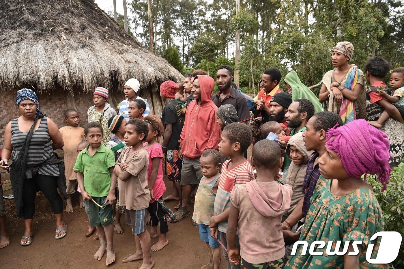 파푸아뉴기니에서 마녀로 몰린 한 여성의 집 앞에 모여있는 군중. ⓒ AFP=뉴스1