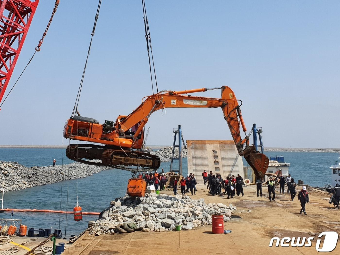 군산해양경찰서가 지난 4월 새만금 신항만 공사현장 부근에서 골재하역작업 도중 바다로 추락한 굴삭기를 인양하고 있다.ⓒ 뉴스1