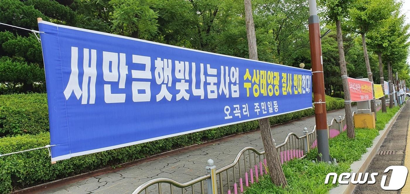 한국농어촌공사가 새만금 농생명용지에 67㎿급 규모의 수상태양광 설치를 추진하자 지역주민들이 주민수용성이 제고되지 않았다면 군산시내 곳곳에 반대 현수막을 내걸고 중단을 촉구하고 있다.ⓒ 뉴스1