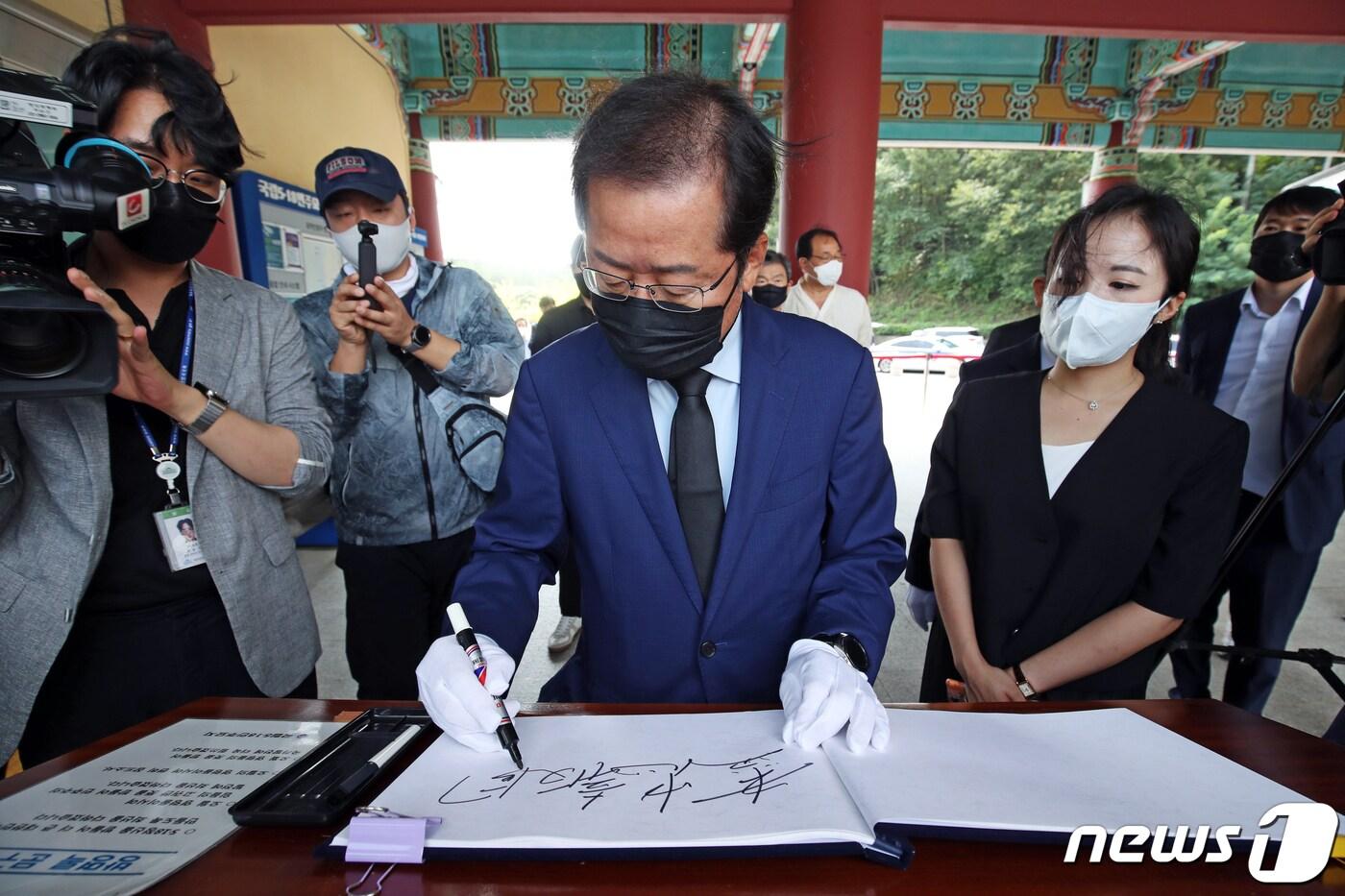 대선 출마를 공식 선언한 홍준표 국민의힘 의원이 20일 오전 광주 북구 운정동 국립5·18민주묘지에서 참배에 앞서 방명록에 &#39;盡忠報國&#40;진충보국, 충성을 다해 나라의 은혜에 보답한다&#41;&#39;을 적고 있다. 2021.8.20/뉴스1 ⓒ News1 자료 사진