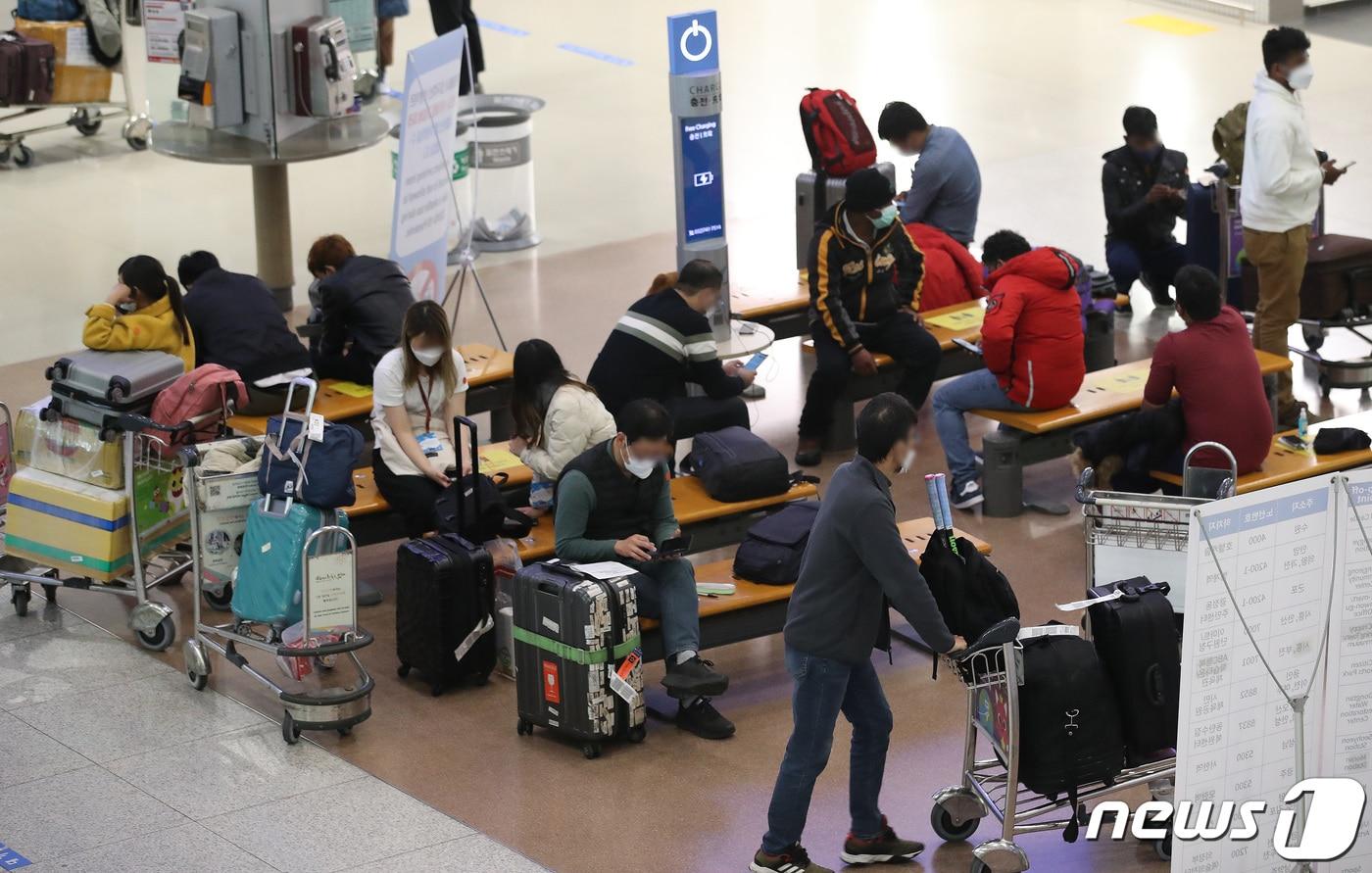 코로나19 오미크론 변이 바이러스가 빠르게 확산되고 있는 26일 인천국제공항 터미널1에서 입국자들이 대기하고 있다. 2022.1.26/뉴스1 ⓒ News1 임세영 기자