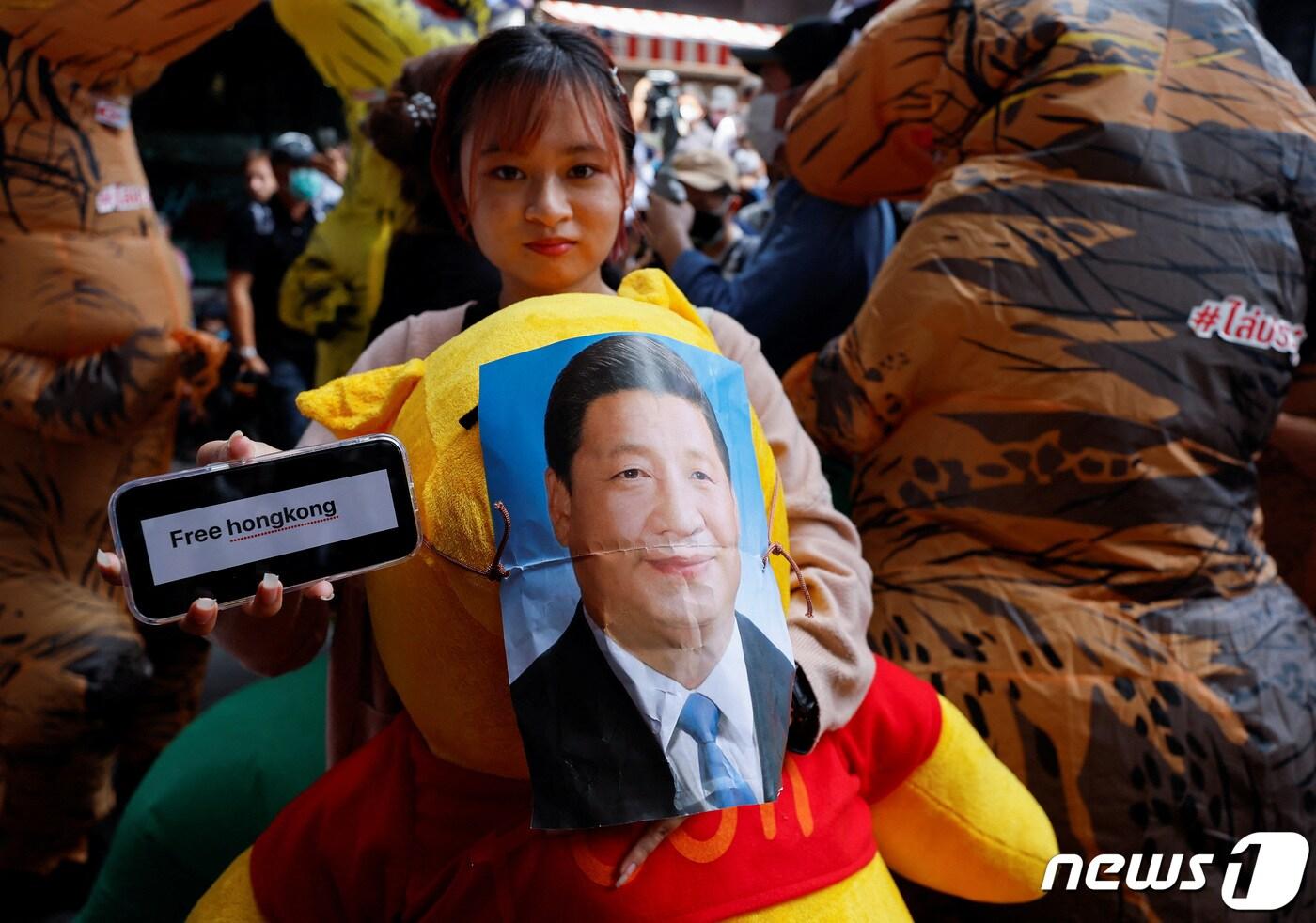 태국 방콕에서 열리는 아시아태평양경제협력체&#40;APEC&#41; 정상회의를 앞둔 17일&#40;현지시간&#41; 여성 시위자가 시진핑 중국 국가주석의 초상화를 &#39;위니더푸&#39; 곰돌이 인형에 붙이며 평화를 촉구하는 시위를 벌이고 있다. ⓒ 로이터=뉴스1 ⓒ News1 정윤영 기자