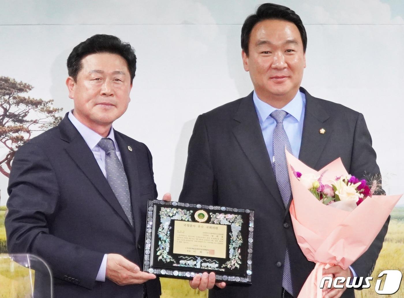 국민의힘 정희용 의원&#40;오른쪽&#41;이 21일 이학구 한농연 중앙회장으로부터 국정감사 우수회원으로 선정된 뒤 패를 받고 있다. &#40;정희용 의원실 제공&#40; 2022.11.21&#41;/뉴스1