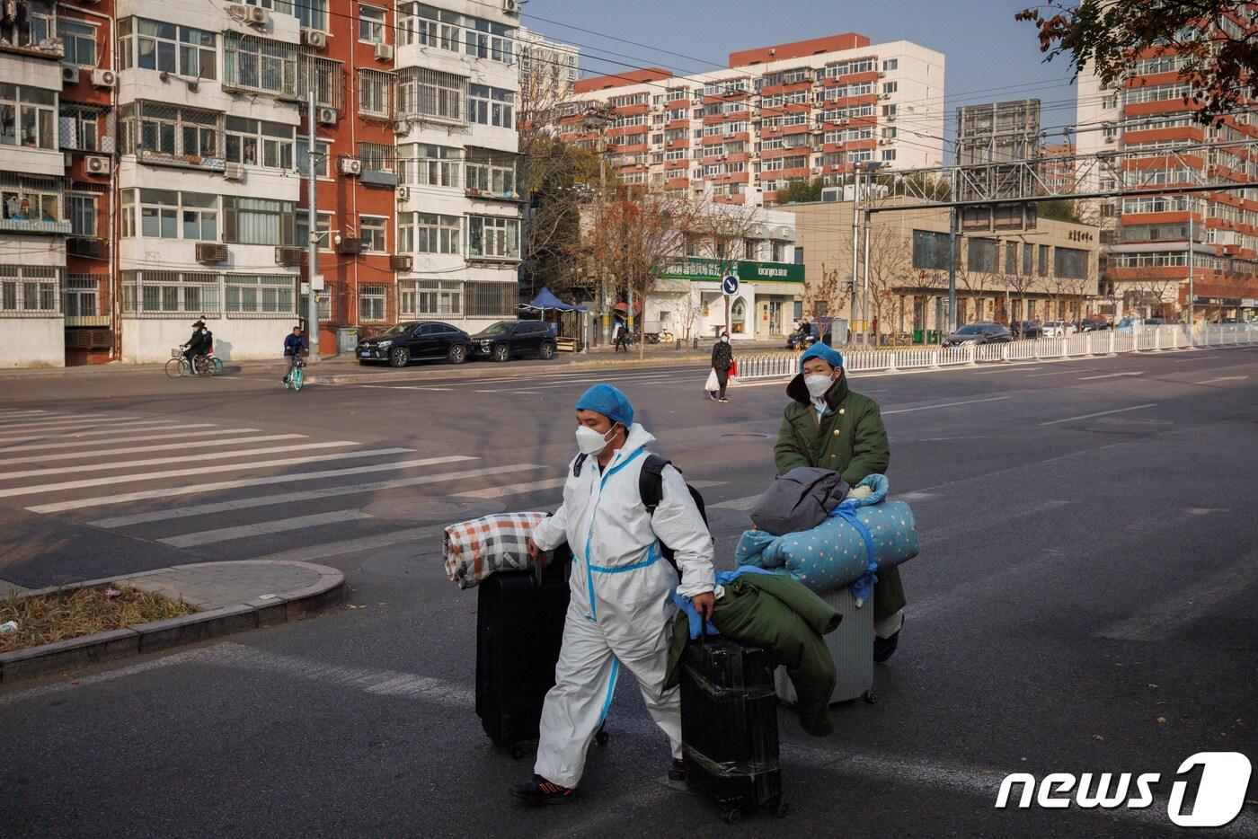 23일 중국 베이징에서 신종 코로나바이러 감염증&#40;코로나19&#41;가 확산함에 따라 방역 위생 관계자들이 짐을 들고 출근하고 있는 모습. 2022.11.23/뉴스1 ⓒ 로이터=뉴스1 ⓒ News1 김민수 기자