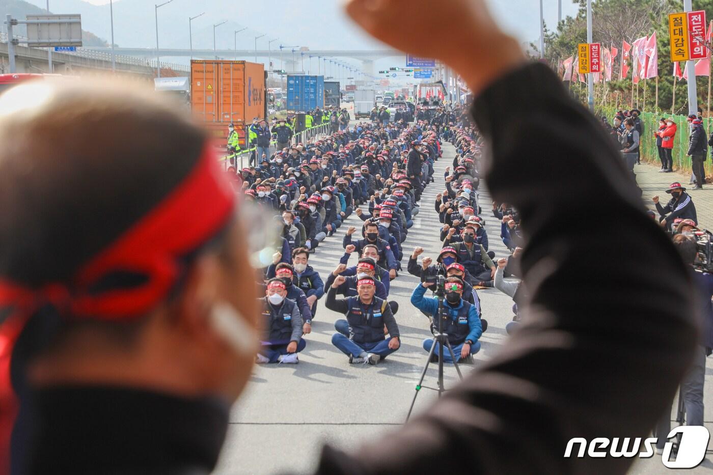 민주노총 공공운수노조 화물연대본부가 무기한 총파업에 돌입한 24일 오전 부산 강서구 부산신항 인근에서 화물연대 조합원들이 구호를 외치고 있다. 화물연대는 이날부터 서울, 경기, 인천 등 전국 16개 본부에서 안전운임제 일몰제 폐지, 안전운임 차종·품목 확대 등을 요구하는 동시 총파업 출정식을 열고 총파업에 돌입한다. 2022.11.24/뉴스1 ⓒ News1 김영훈 기자