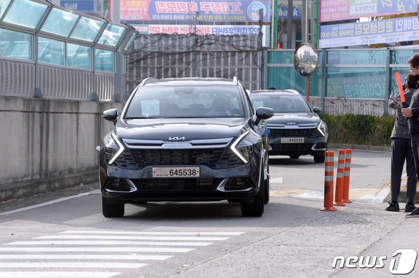 민주노총 전국공공운수노동조합 화물연대본부 파업 2일차인 25일 오전 광주 서구 광천동 기아 오토랜드 광주공장에서 협력업체 운송사인 글로비스 직원들이 임시번호판과 임시운행 허가증을 발급받은 완성차를 광산구 평동공단 출하장과 장성 물류센터 등으로 직접 옮기고 있다.  2022.11.25/뉴스1 ⓒ News1 이승현 기자