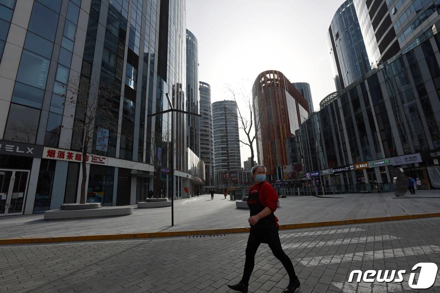 중국 수도 베이징에서 4000명에 육박하는 코로니19 신규 확진자가 나온 28일 한 식당 종업원이 빌딩 사이를 지나가고 있다. ⓒ 로이터=뉴스1 ⓒ News1 최종일 기자