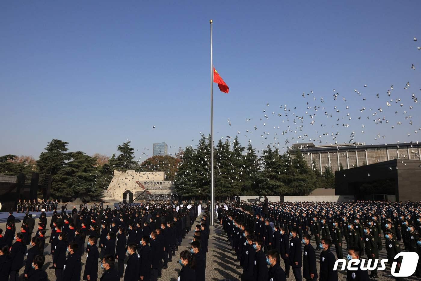 13일 중국 동부 장수성 난징에 있는 난징대학살 기념관에서 난징대학살 85주기 추모식이 열린 가운데 참석자들이 묵념하고 있다. ⓒ AFP=뉴스1