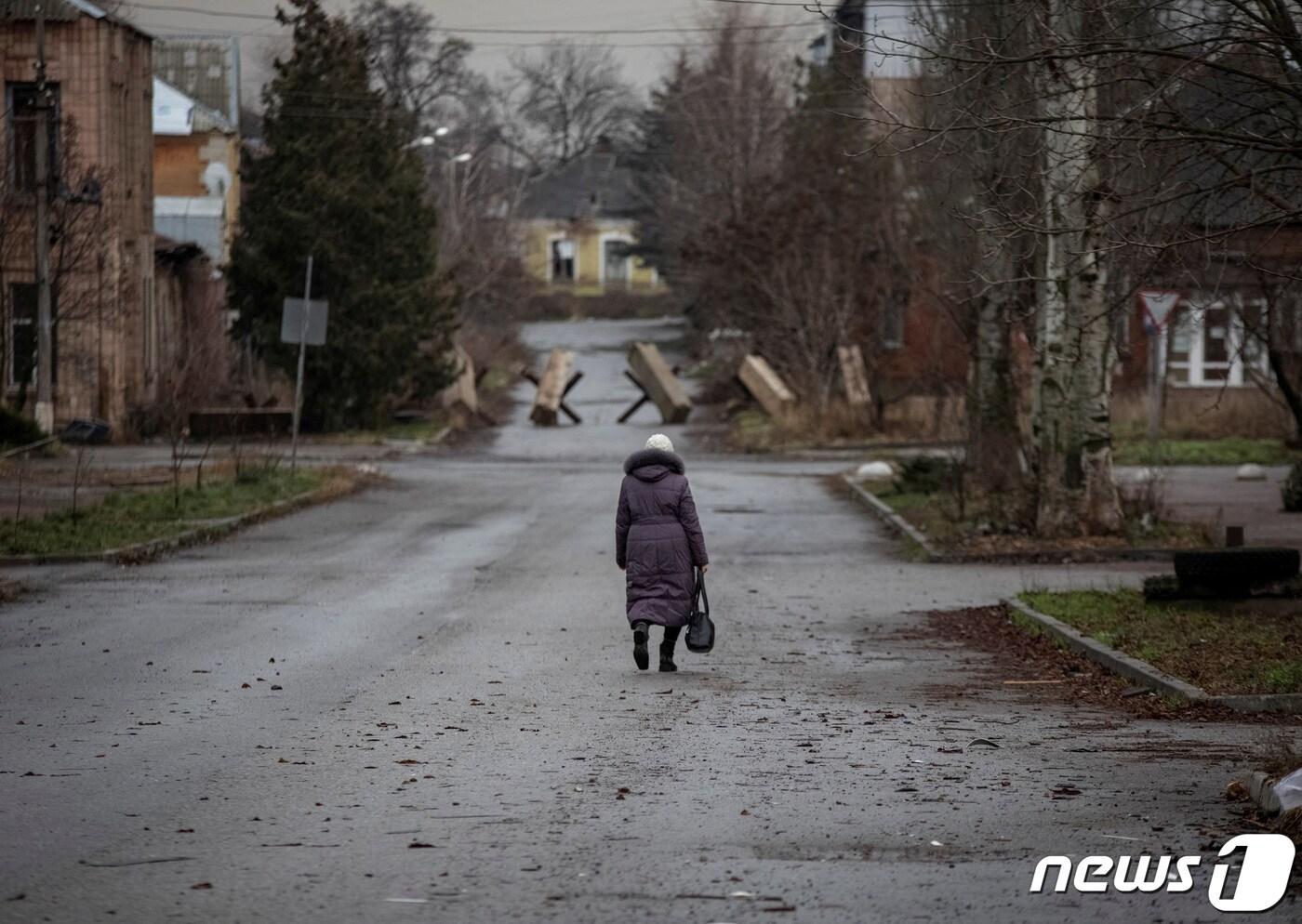 18일&#40;현지시간&#41; 러시아의 우크라이나 침공이 이어지는 가운데 우크라이나 바흐무트에서 한 여성이 황량한 거리를 걷고 있다. 22.12.18 ⓒ 로이터=뉴스1 ⓒ News1 김예슬 기자