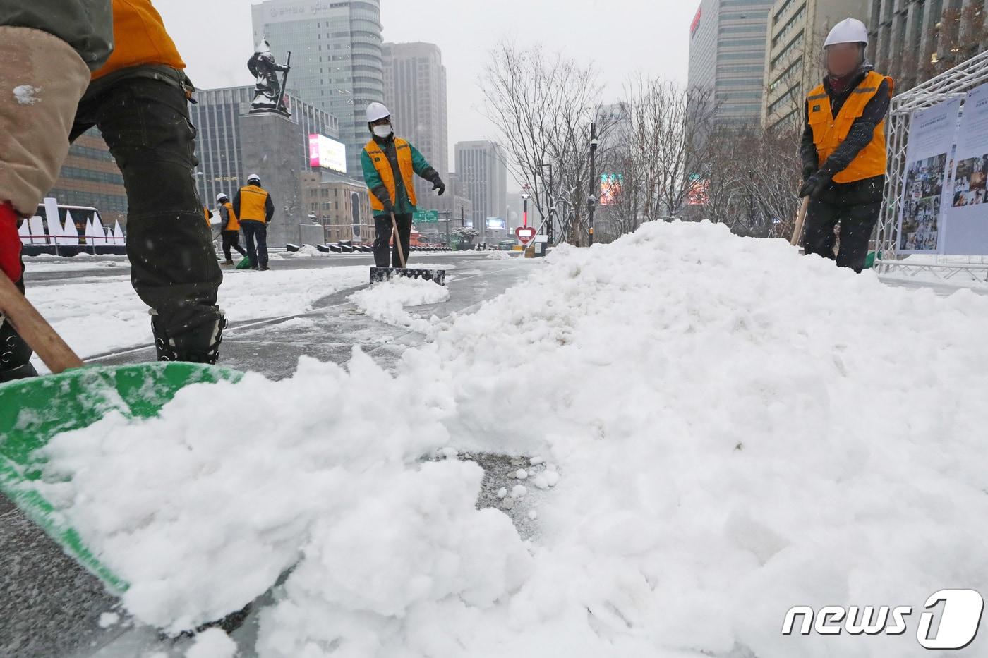 서울을 비롯해 중부지방에 대설특보가 발효된 21일 오전 서울 종로구 광화문광장 일대에서 중부공원여가센터 관계자들이 눈을 치우고 있다. 2022.12.21/뉴스1 ⓒ News1 조태형 기자