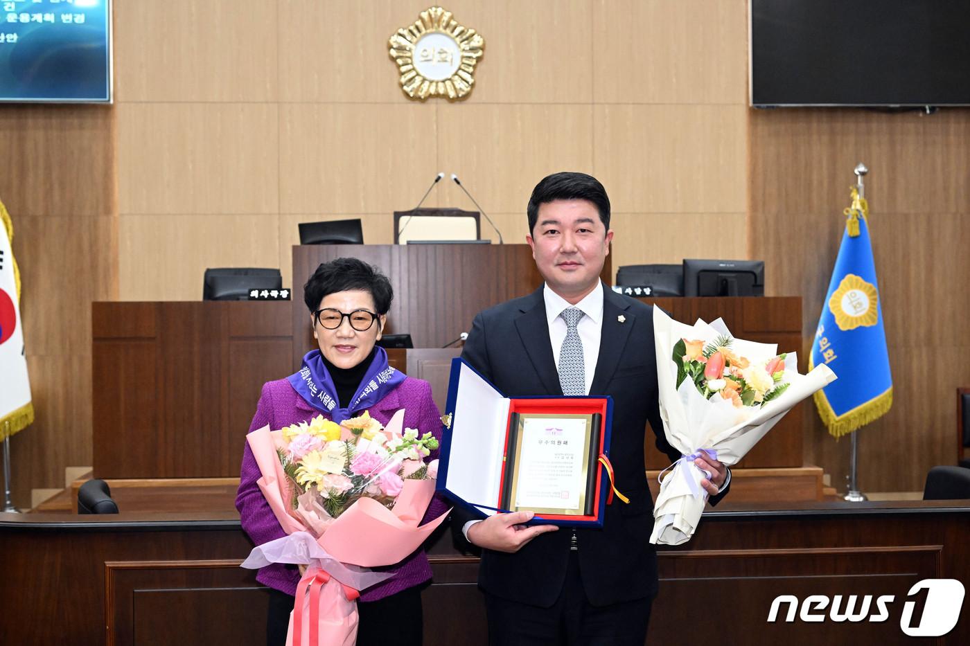 울주군의회 의사당 본회의장에서 &#40;사&#41;의회를 사랑하는 사람들 울주군지회로부터 의정활동 우수의원으로 뽑힌 김시욱 의원이 패를 전달 받고 이미경 회장과 기념촬영을 하고 있다.