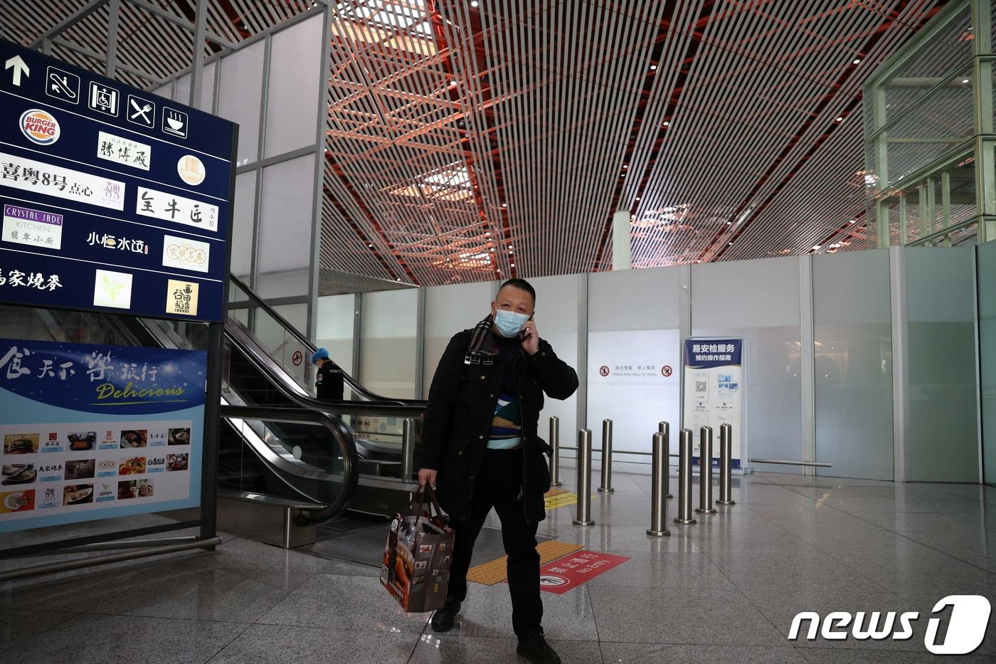 중국 베이징 서우두 국제공항 터미널에서 한 남성이 길을 걷고 있다. 2022.03.23. ⓒ 로이터=뉴스1 ⓒ News1 정윤영 기자