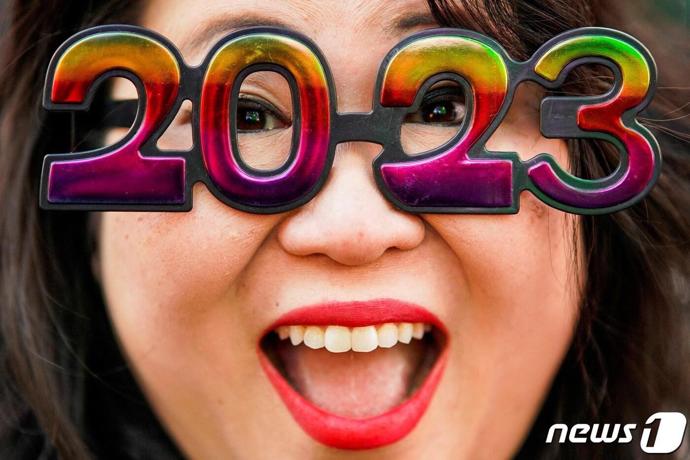 20일&#40;현지시간&#41; 미국 뉴욕 타임스퀘어에서 한 여성이 새해를 앞두고 2023년을 기념하는 안경을 착용하고 있다. ⓒ 로이터=뉴스1 ⓒ News1 정윤영 기자