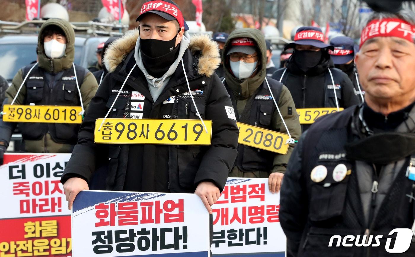 7일 오후 세종시 정부세종청사 국토교통부 앞에서 열린 민주노총 공공운수노조 화물연대본부 집회에서 노조원들이 화물차 번호판을 목에 걸고 정부의 업무개시명령을 규탄하며 안전운임제 일몰제 폐지 등을 요구하고 있다. 2022.12.7/뉴스1 ⓒ News1 김기남 기자