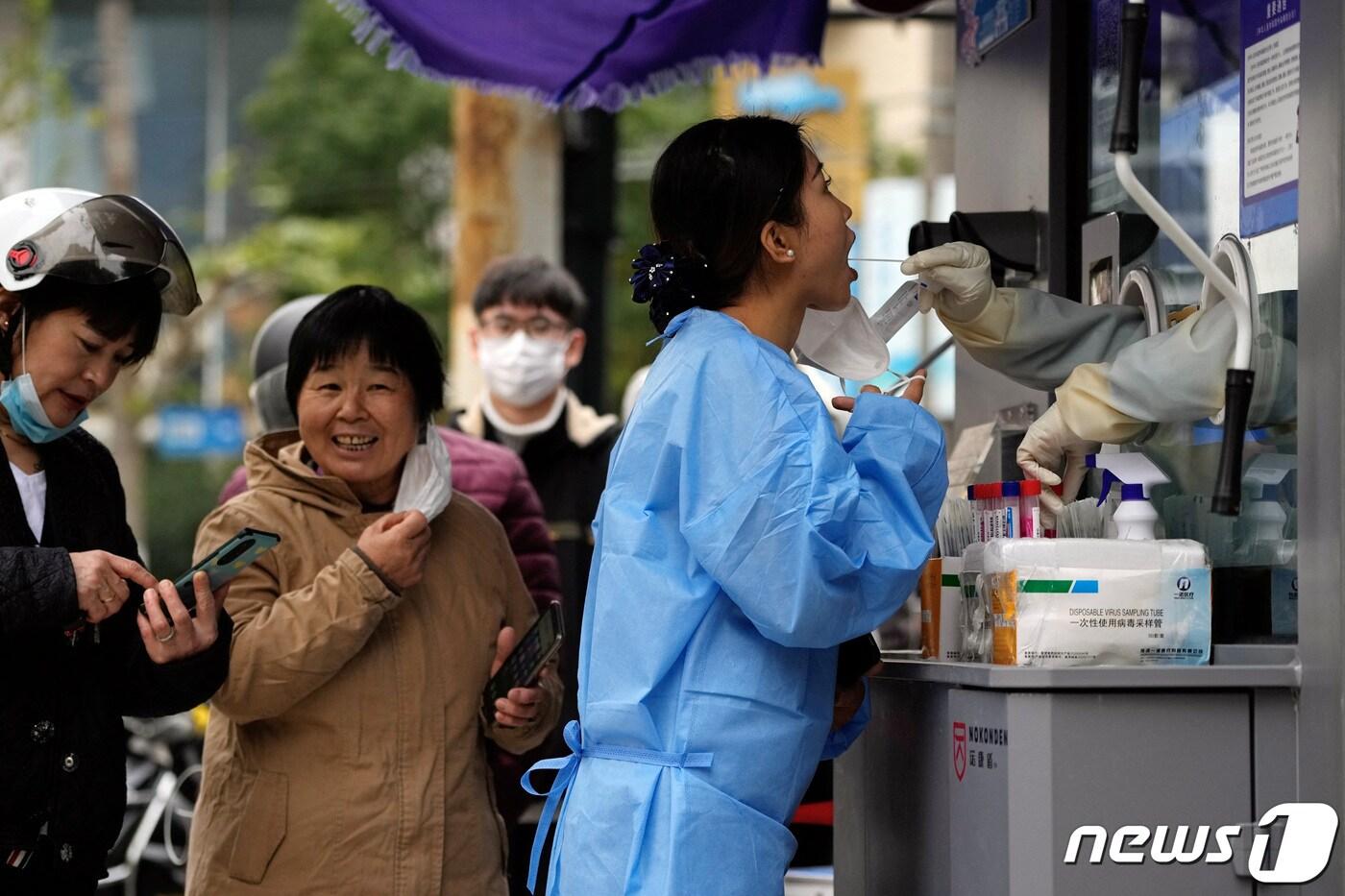 7일 중국 상하이의 핵산 검사소에서 한 여성이 PCR 검사를 받고 있다. 2022.12.07/뉴스1 ⓒ 로이터=뉴스1 ⓒ News1 김민수 기자