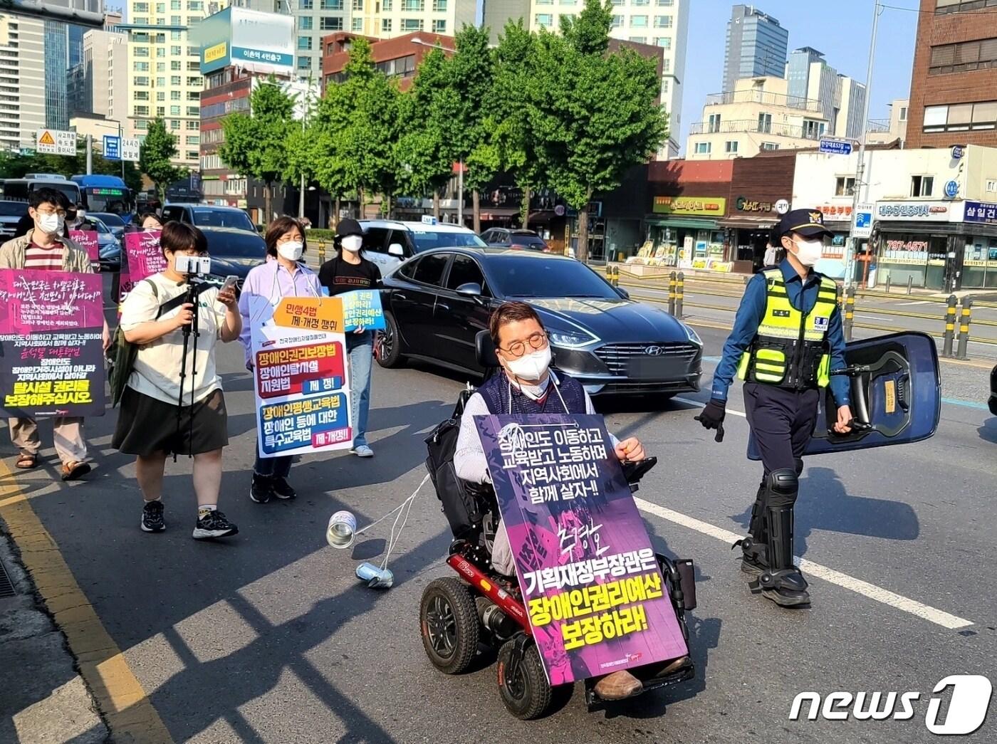 전국장애인차별철폐연대 회원들이 19일 오전 서울 용산구 신용산산역에서 삼각지역까지 &#39;장애인 권리예산 22년 추경 반영을 위한 긴급행동&#39; 행진 시위를 진행하고 있다. ⓒ 뉴스1 조현기 기자