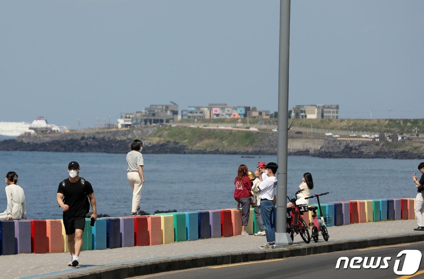 어린이날인 5일 제주시 용두암 해안도로에 있는 무지개도로에서 관광객들이 경치를 구경하거나 셀카를 찍고 있다.2022.5.5/뉴스1 ⓒ News1 고동명 기자