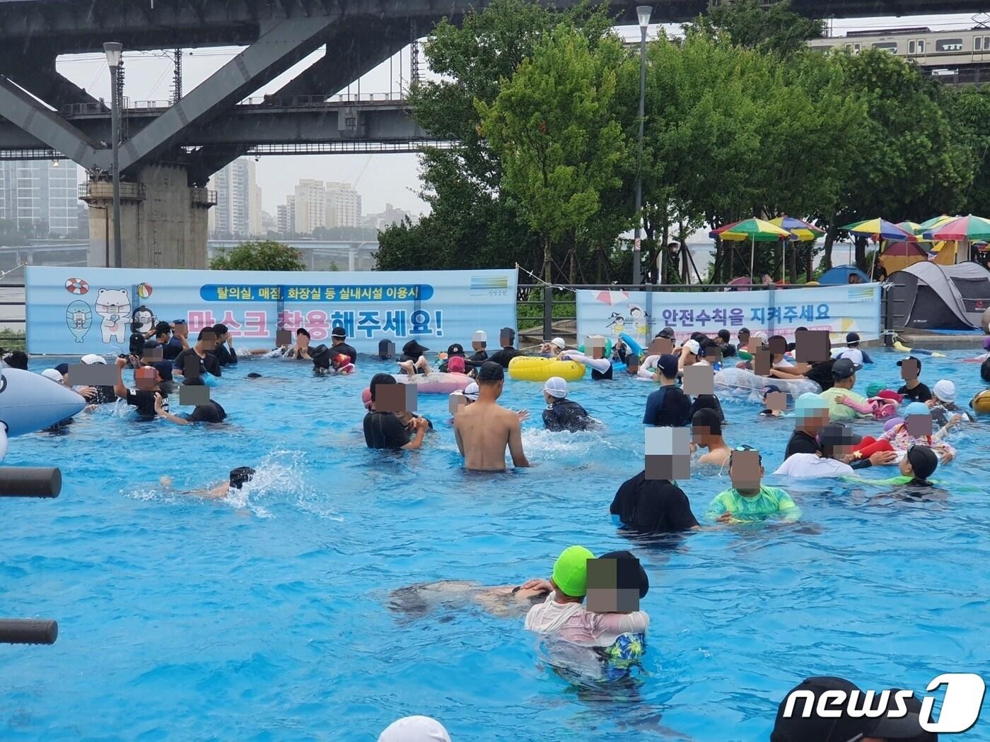 31일 오후 서울 광진구 뚝섬한강공원수영장에서 시민들이 물놀이를 즐기고 있다. 이용객들 뒤로 실내 마스크 착용 관련 안내문이 붙어있다. 2022.07.31/ ⓒ 뉴스1 권진영 기자