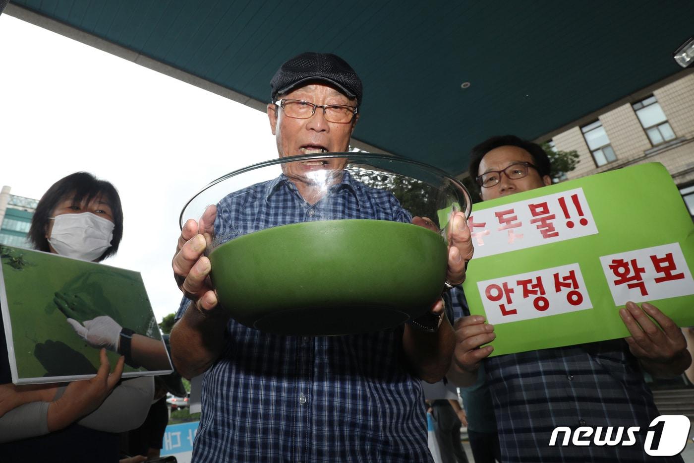 낙동강네트워크·낙동강대구경북네트워크 등 영남권 환경단체 회원들이 지난해 8월 1일 달성군 매곡정수장 인근 낙동강에서 퍼온 물을 투명 용기에 따른 뒤 대구시장 항의방문과 서한문 전달을 시도하고 있다. 2022.8.1/뉴스1 ⓒ News1 공정식 기자