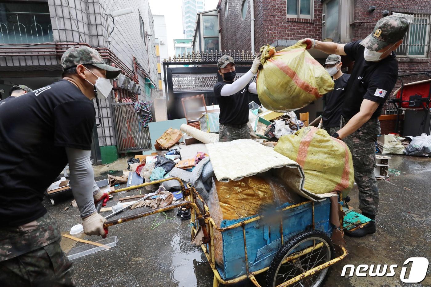 집중호우로 인해 중부지방 곳곳이 침수 피해를 입은 가운데 11일 오후 경기 군포시 산본동 금정역 일대에서 육군 제51보병사단 예비군지휘관과 상근예비역들이 침수 피해 복구 작업을 하고 있다. 2022.8.11/뉴스1 ⓒ News1 김영운 기자