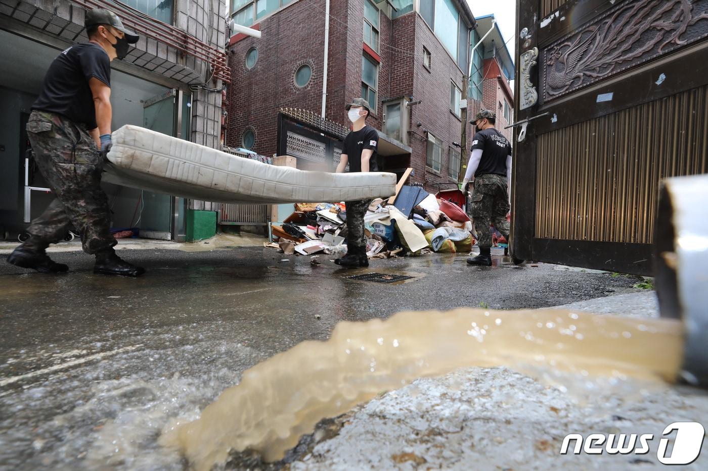 집중호우로 인해 중부지방 곳곳이 침수 피해를 입은 가운데 11일 오후 경기 군포시 산본동 금정역 일대에서 육군 제51보병사단 예비군지휘관과 상근예비역들이 침수 피해 복구 작업을 하고 있다. 2022.8.11/뉴스1 ⓒ News1 김영운 기자