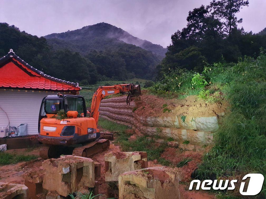 11일 오후 충북 괴산군 불정면 신흥리의 한 주택 뒤쪽에 설치된 보강토 블록이 붕괴 조짐을 보여 응급 조치를 하는 동안 일가족 4명이 경로당으로 대치했다가 귀가했다. 사진은 보강토 불록 철거 모습.&#40;괴산소방서 제공&#41;2022.8.11/ⓒ 뉴스1