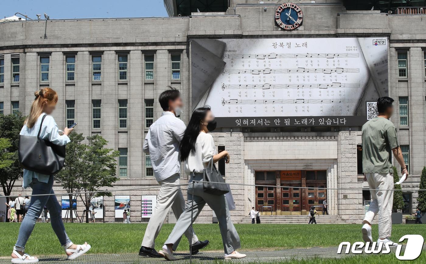 12일 제77회 광복절을 앞두고 &#39;광복절 노래&#39;의 악보로 단장한 서울시청 앞 서울도서관 외벽 광복절 기념 꿈새김판 앞으로 시민들이 지나가고 있다. 서울시는 &#34;광복절에는 시민들이 &#39;광복절 노래&#39;에 관심을 갖고 담긴 가사를 찬찬히 들여다보며 광복의 감격과 의미를 되짚어 보는 시간을 가졌으면 하는 바람으로 광복절 기념 꿈새김판을 준비했다＂고 말했다. 2022.8.12/뉴스1 ⓒ News1 임세영 기자