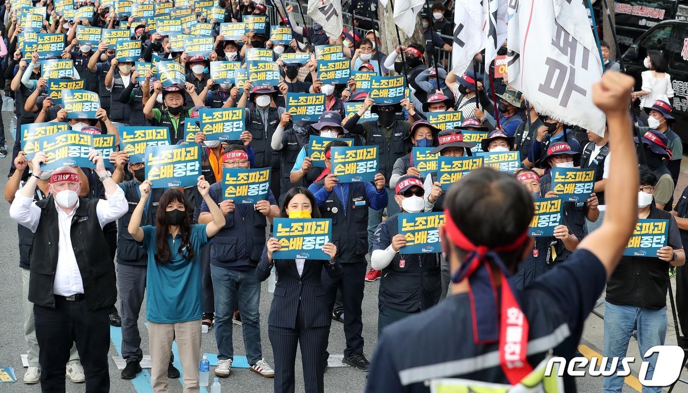 민주노총 공공운수노조 조합원들이 18일 하이트진로 본사 앞에서 열린 화물연대 고공농성투쟁 승리 결의대회에서 손팻말을 들고 구호를 외치고 있다. 2022.8.18/뉴스1 ⓒ News1 김진환 기자