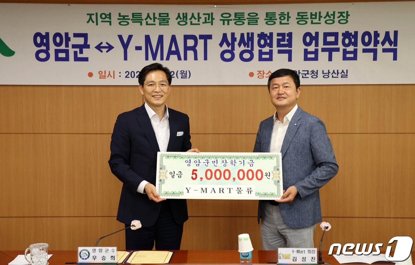 김성진 Y-마트물류 회장&#40;오른쪽&#41;이 영암군과 상생협력 협약식 이후 장학금 500만원을 우승희 군수에게 전달했다./뉴스1