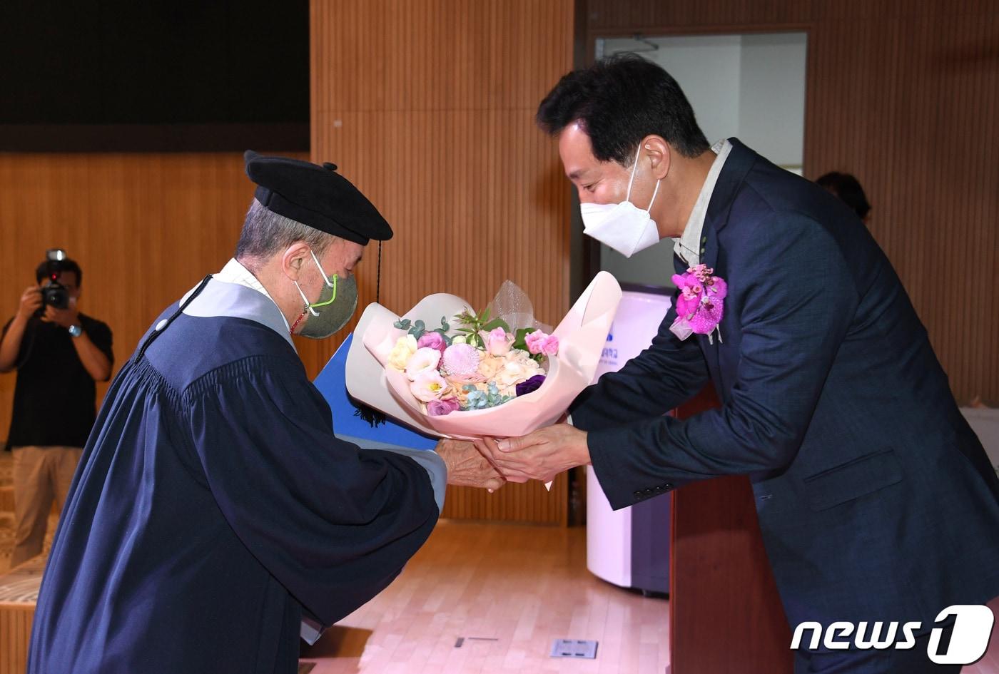 오세훈 서울시장이 25일 오후 서울 동대문구 전농동 서울시립대 100주년기념관 국제회의장에서 열린 2022년 서울시 희망의 인문학 심화과정 소통·공존·치유의 인문학 수료식에서 수료자에게 꽃다발을 전달하고 있다. &#40;서울시 제공&#41; 2022.8.25/뉴스1