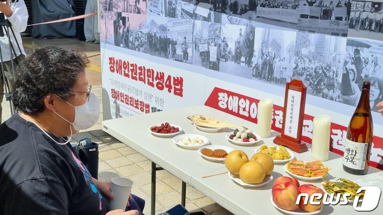 전국장애인차별철폐연대&#40;전장연&#41; 회원이 10일 서울 영등포구 여의도동 이룸센터  앞에서 추석 차례상을 지내고 장애인권리예상 보장을 촉구했다.  ⓒ 전장연 제공