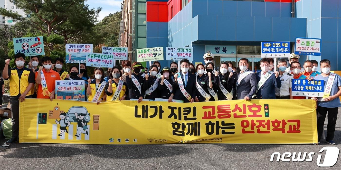 계룡시가 19일 논산경찰서, 계룡녹색어머니회 회원 등 30여 명이 참여한 가운데 신도초등학교 앞에서 ‘어린이 교통안전 캠페인’을 벌였다. &#40;계룡시 제공&#41;