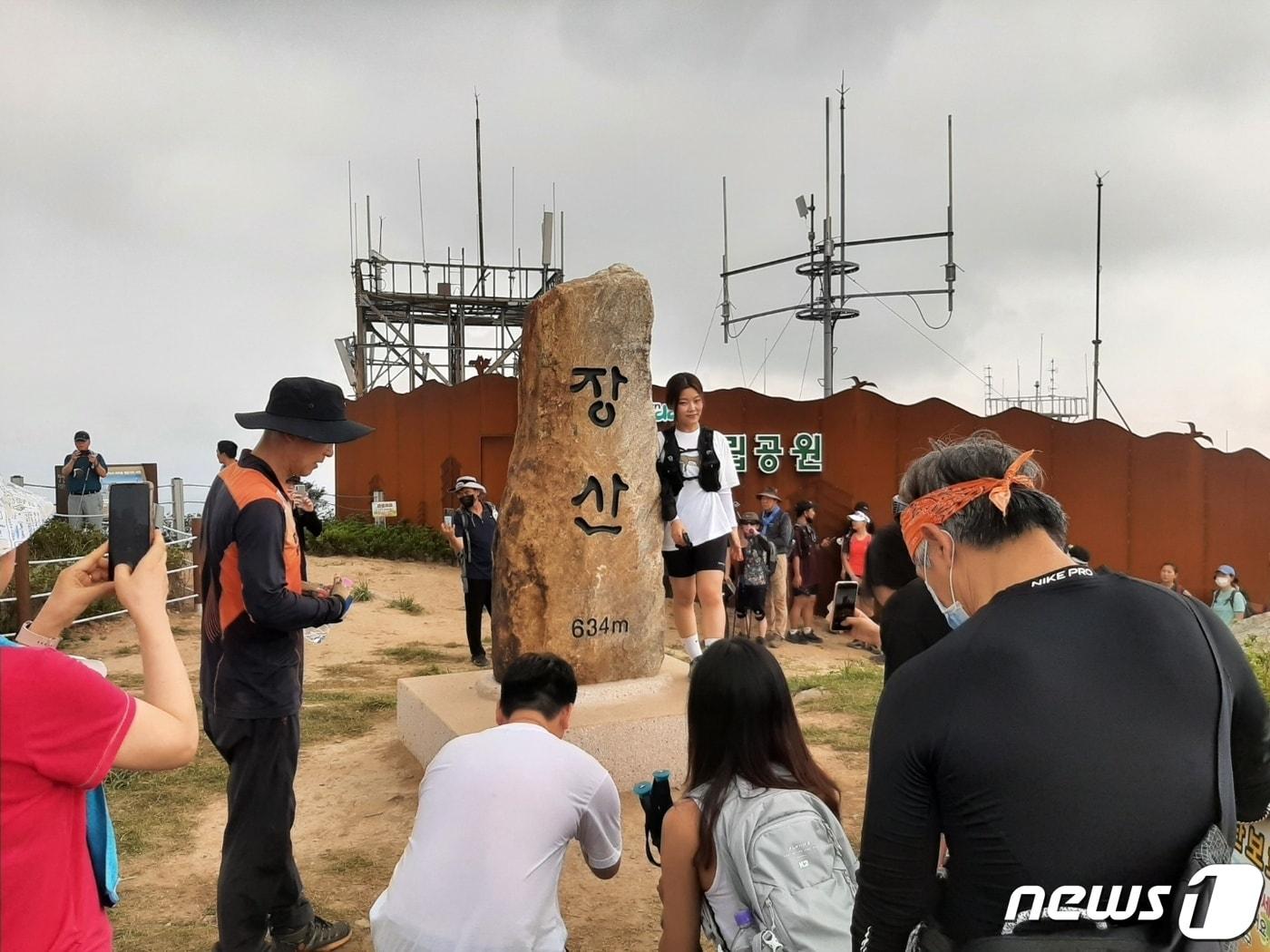 부산 해운대구 장산 정상을 찾은 시민들이 표지석에서 기념촬영을 하고 있다.&#40;해운대구 제공&#41;