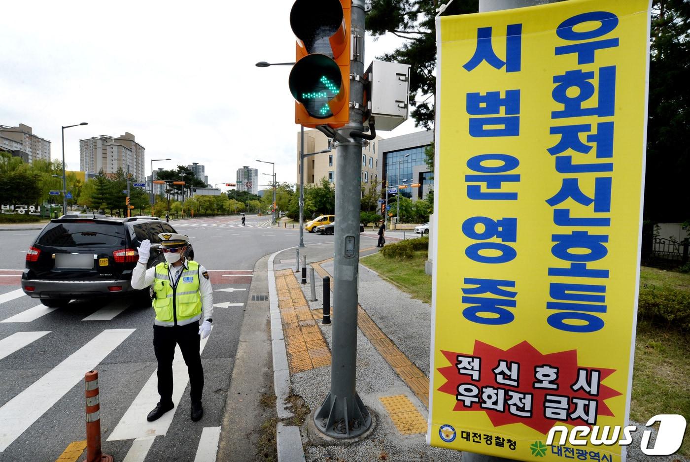 유성경찰서 교통안전계 소속 경찰관들이 22일 대전 유성구 원신흥네거리에서 &#39;우회전 신호등&#39; 시범운영 계도 및 지도를 하고 있다.  2022.9.22/뉴스1 ⓒ News1 김기태 기자