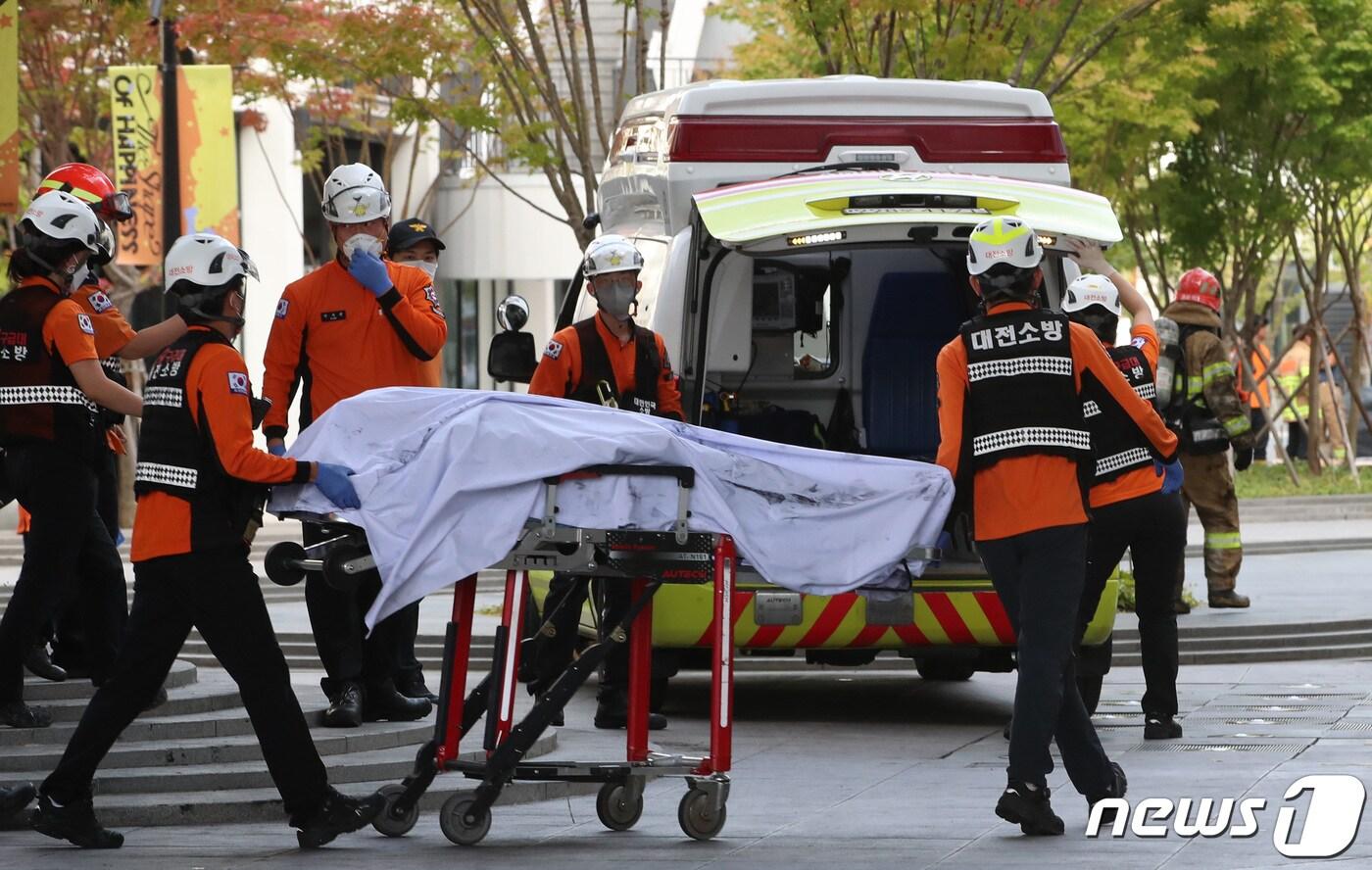 26일 오전 대전 유성구 용산동 현대프리미엄 아울렛 지하에서 발생한 화재로 총 7명이 사망하고 1명이 중상을 입었다. 이날 오후 4시20분께 소방 구조대원들이 현장에서 발견한 사망자를 구급차로 이송하고 있다. 2022.9.26/뉴스1 ⓒ News1 김기태 기자